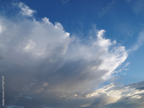 Ant's eye view of dark clouds moving with blue sky background.