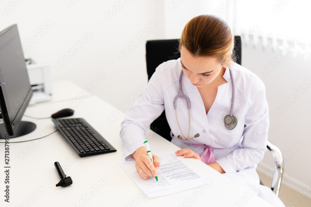 Young blonde doctor working on computer in new clinic. Helthcare concept Young blonde doctor working on computer in new clinic. Helthcare concept