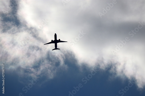 Airplane flying in the sky. Silhouette of a passenger plane taking off on background of storm clouds