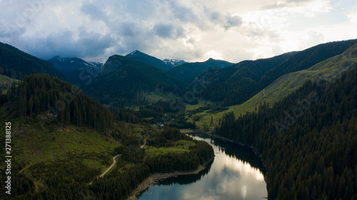 Aerial drone shot of a lake and green forest in Transylvania  Romania