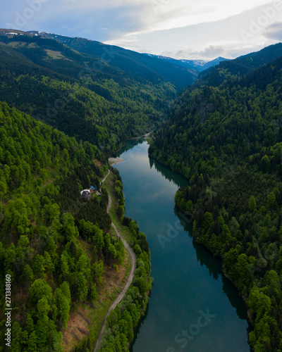 Fototapeta Naklejka Na Ścianę i Meble -  Aerial drone shot of a lake and green forest in Transylvania, Romania