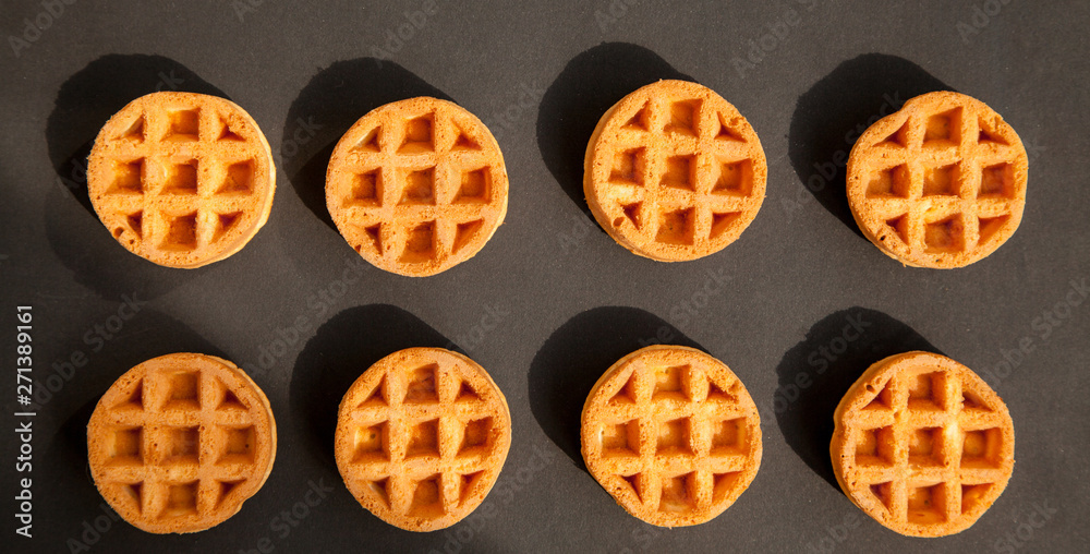 round little Viennese waffles on a black background top view. Sweet background round little Viennese waffles on a black background top view. Sweet background