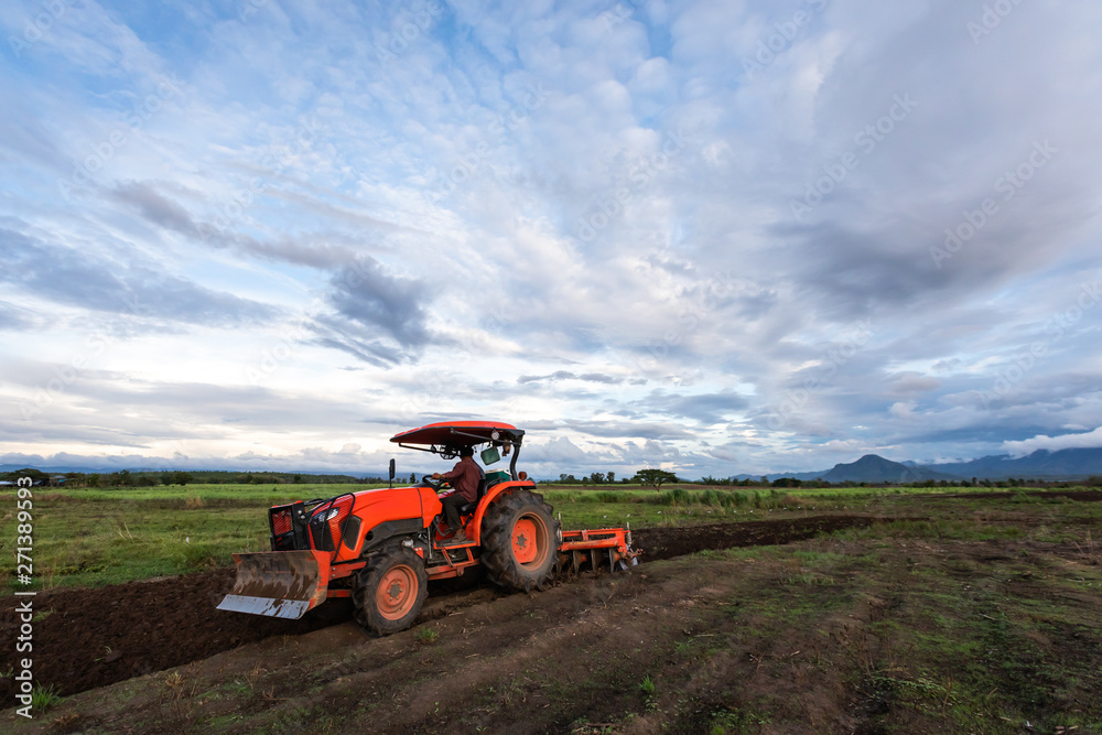 Obraz premium agricultural man working with plowing tractor in the beautiful farmland, Mae Sot, Tak, Thailand
