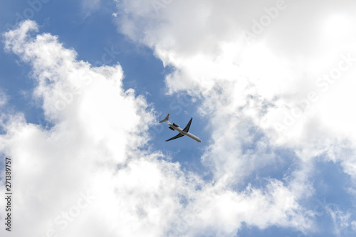 Airplane on a blue sky with soft white clouds.