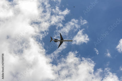 Airplane on a blue sky with soft white clouds.