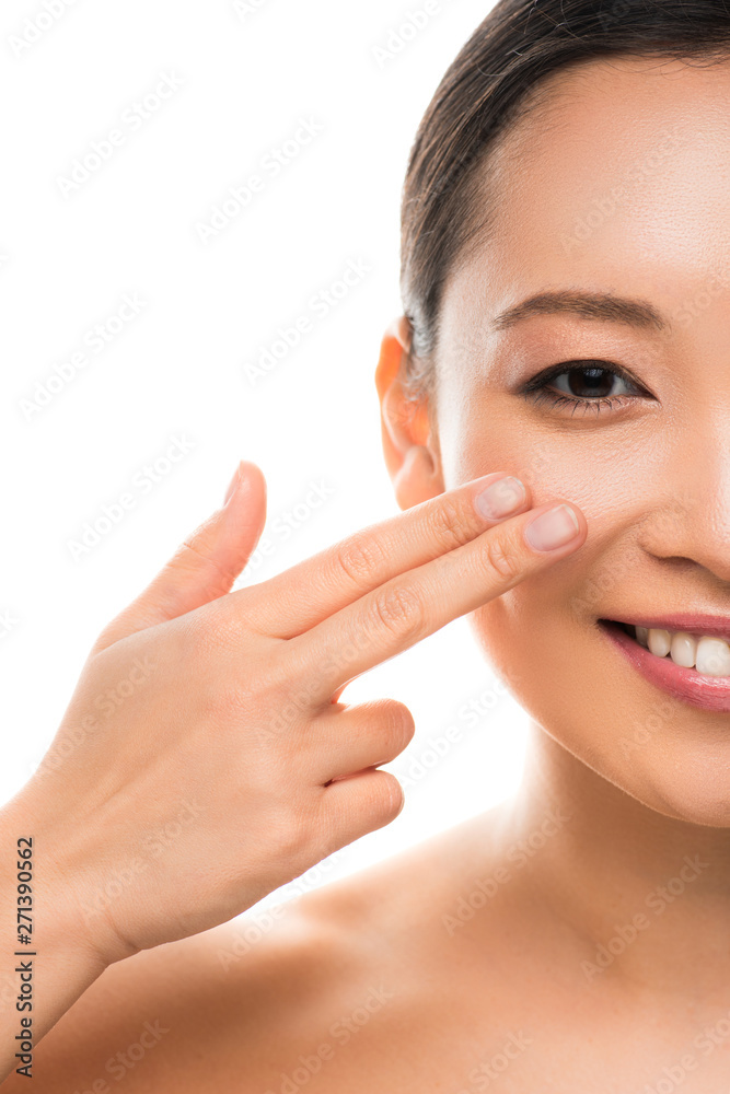 Fototapeta premium beautiful smiling asian girl applying cream, isolated on white