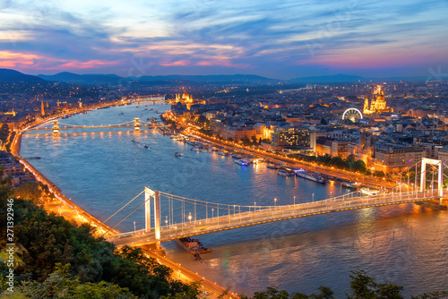 Aerial view of Budapest, Hungary with clouds. Buda castle, Chain bridge and Parliament building at sunset with lights on