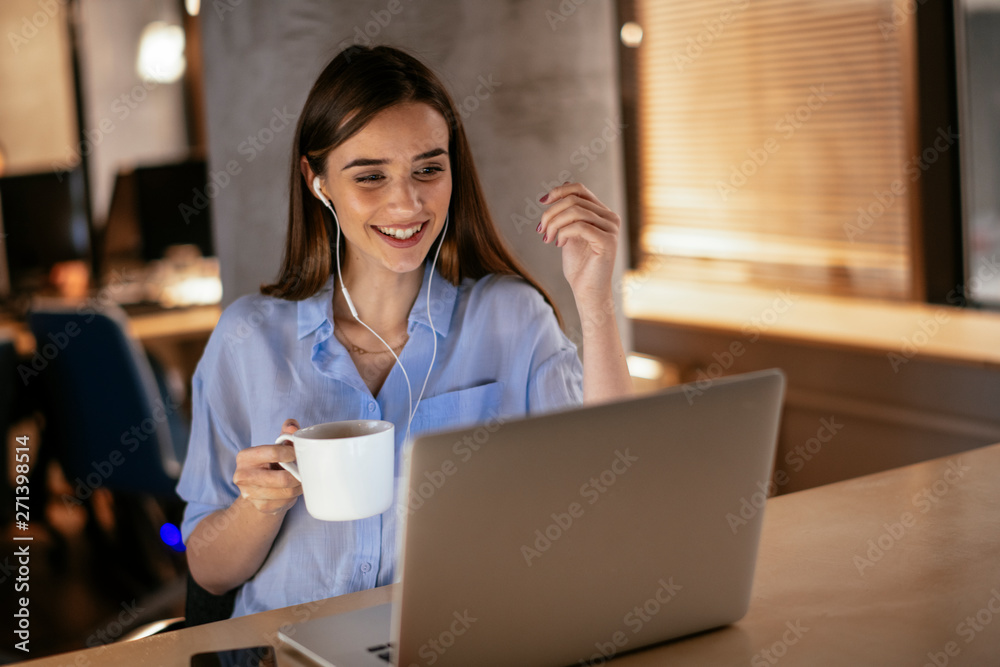 Businesswoman with headphones using laptop