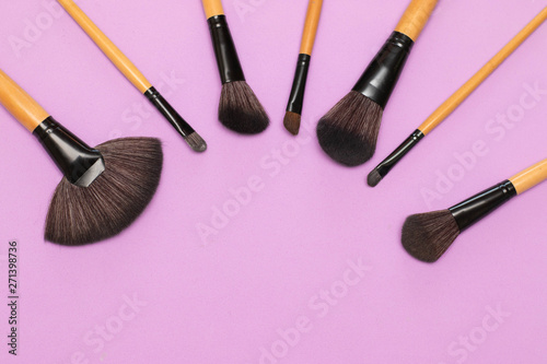 Makeup brushes on lilac background
