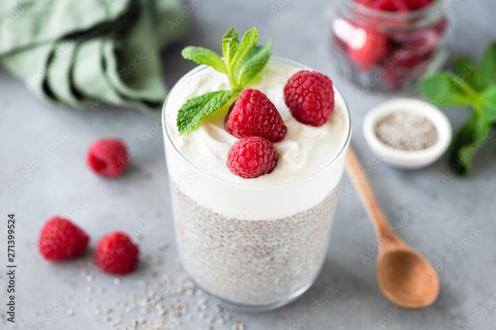 Vegetarian Chia Pudding With Raspberries And Greek Yogurt Layer. Grey Concrete Background Vegetarian Chia Pudding With Raspberries And Greek Yogurt Layer. Grey Concrete Background