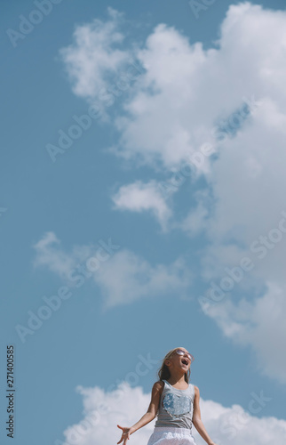 little girl no fear and full of happiness, with open hands. View from below and sky background © karrastock