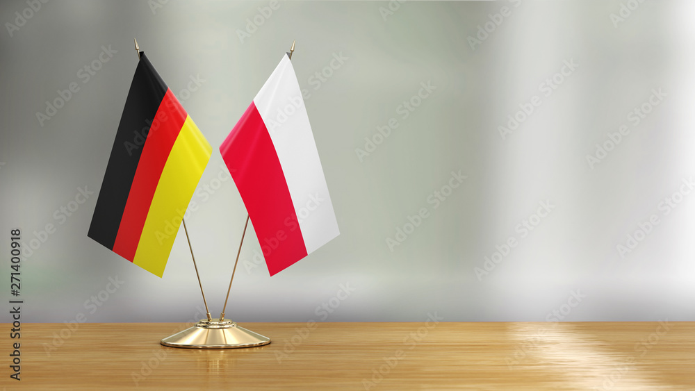 Polish and German flag pair on a desk over defocused background  - obrazy, fototapety, plakaty 