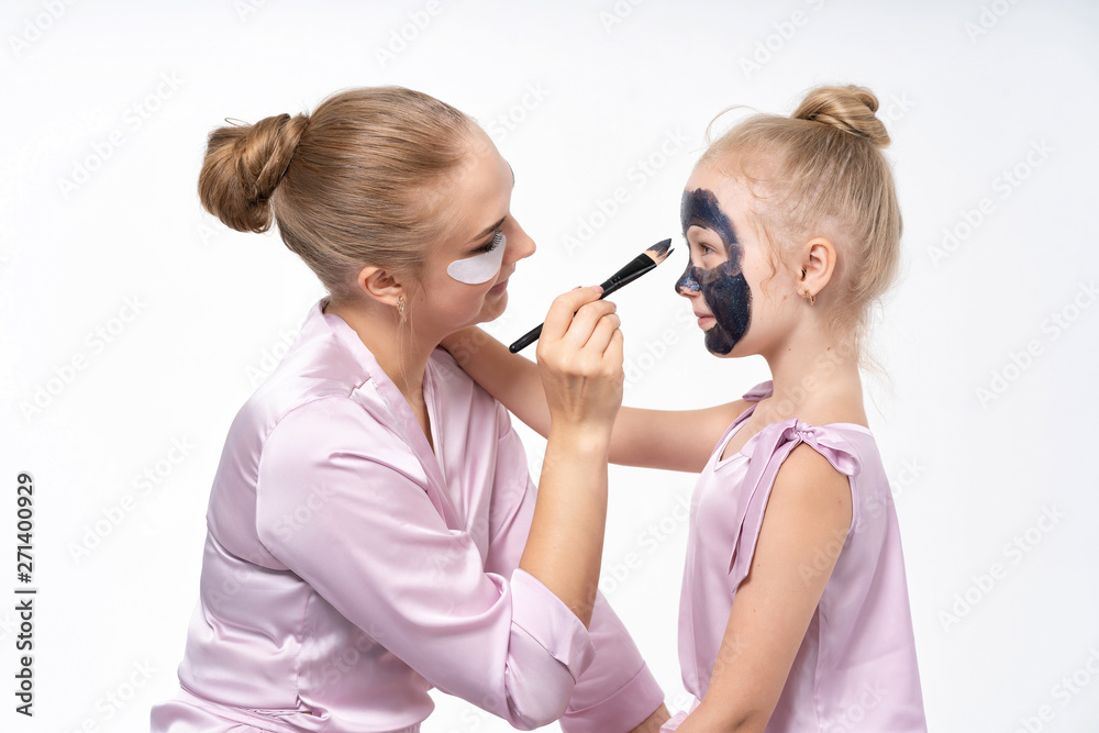 sisters help each other to remove face masks from the face to heal the skin. Have a great time together and have fun.