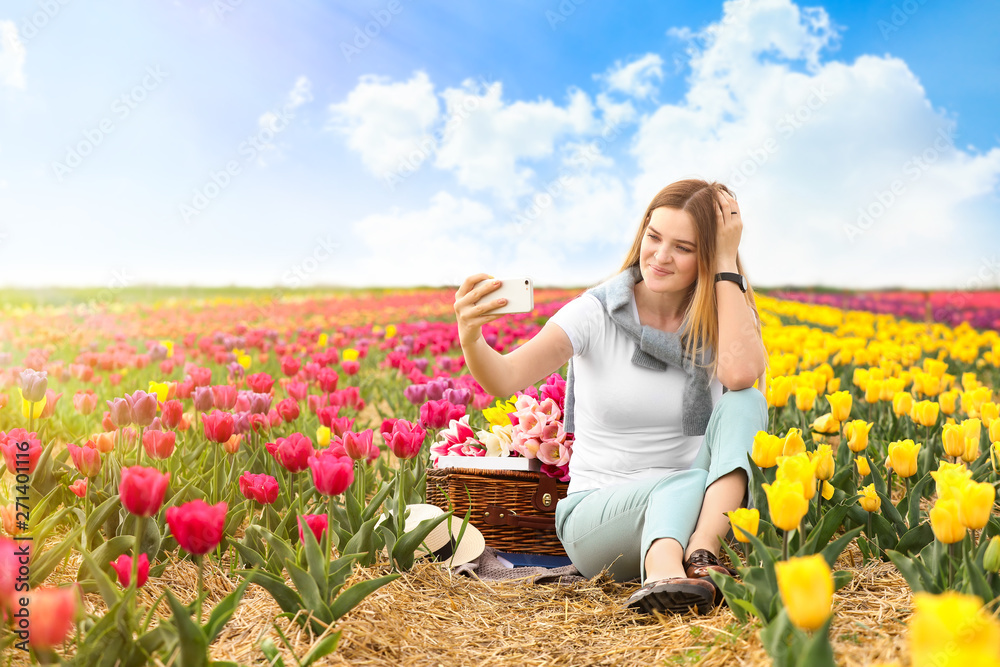Beautiful young woman taking selfie in tulip field on spring day Beautiful young woman taking selfie in tulip field on spring day