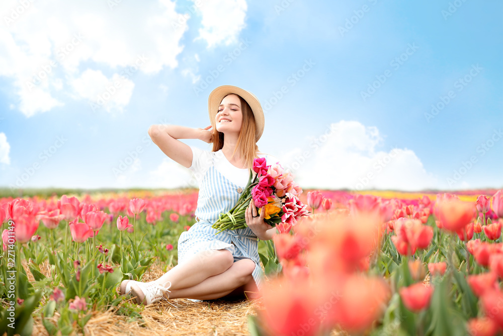 Beautiful young woman with bouquet of fresh tulips in countryside on spring day Beautiful young woman with bouquet of fresh tulips in countryside on spring day
