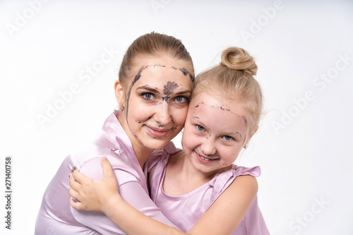 young mothers and young daughter Europeans conduct facial skin care procedures. Family treatments. Cosmetic skin care.