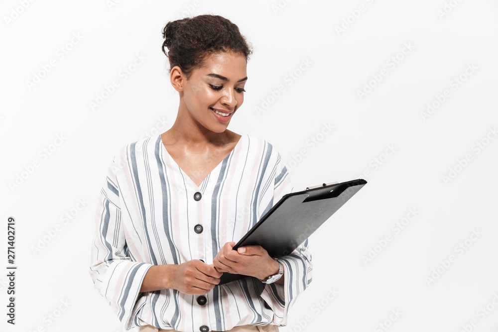 Young beautiful african woman posing isolated over white wall background holding clipboard. Young beautiful african woman posing isolated over white wall background holding clipboard.
