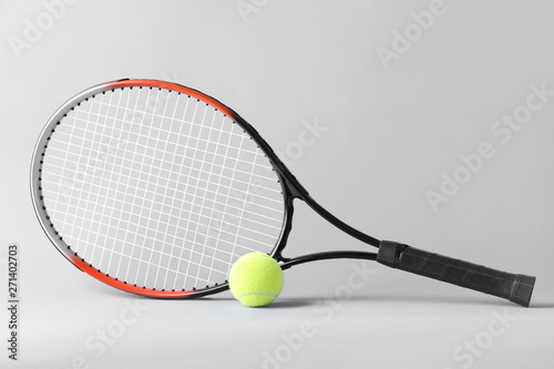 Tennis racket and ball on grey background © Pixel-Shot