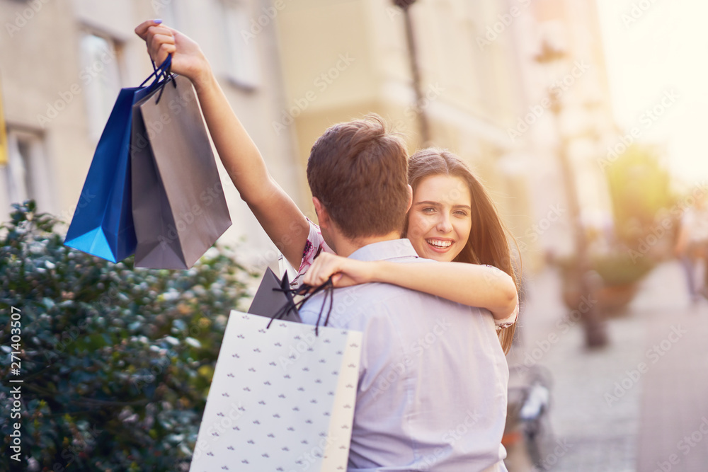 Portrait of happy couple with shopping bags in city smiling and huging. Portrait of happy couple with shopping bags in city smiling and huging.