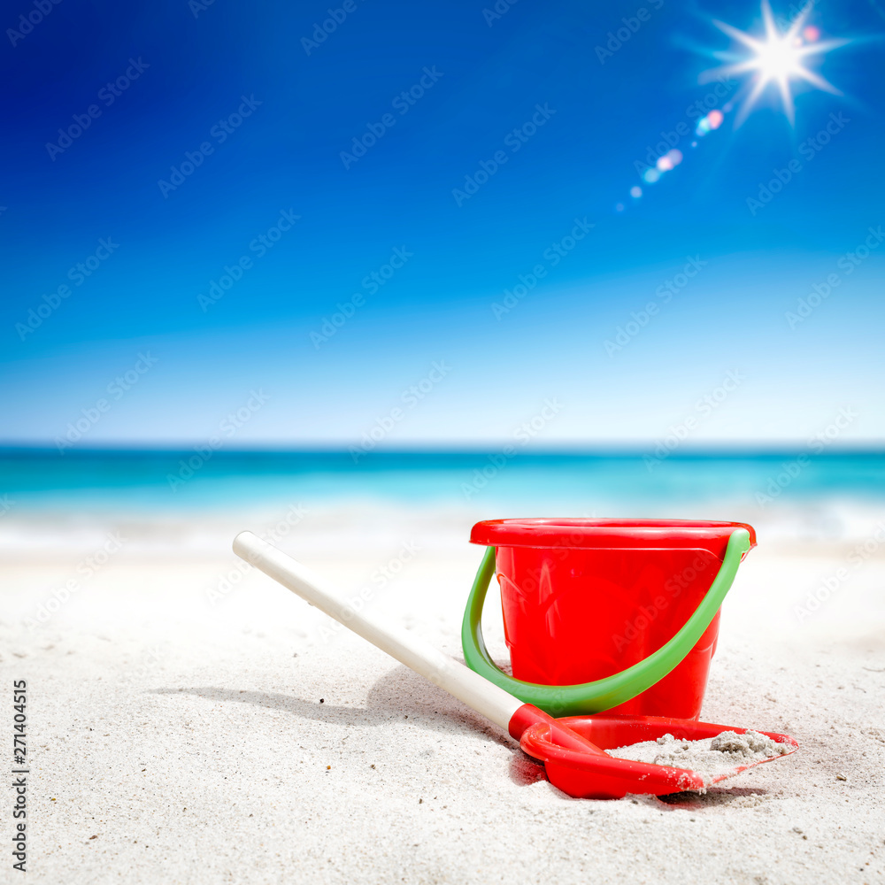 Red plastic bucket with free space for your product. The possibility of mounting bottles with drink, ice cream, food or other products. Blurry beach with people and ocean view. Red plastic bucket with free space for your product. The possibility of mounting bottles with drink, ice cream, food or other products. Blurry beach with people and ocean view.