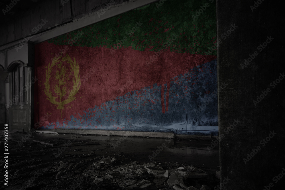 Fototapeta premium painted flag of eritrea on the dirty old wall in an abandoned ruined house.