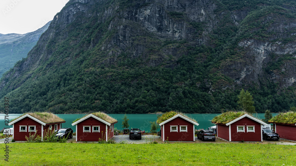 Red wooden cabins on the shore of Oldevatnet lake, in Norway