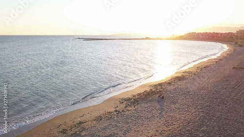 Girl with dog at the beach at sunset. Aerial view and loop shot. Almerimar, Almeria, Spain