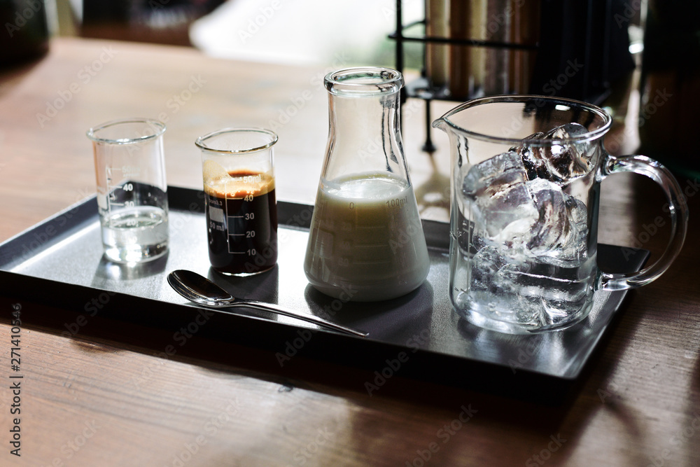 iced coffee latte, ice cubes espresso milk and sweet syrup served in various test tubes on wooden table in morning cafe, selective focus iced coffee latte, ice cubes espresso milk and sweet syrup served in various test tubes on wooden table in morning cafe, selective focus