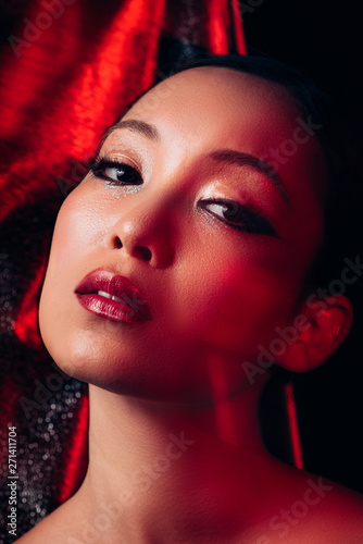 seductive attractive asian girl with makeup in red light