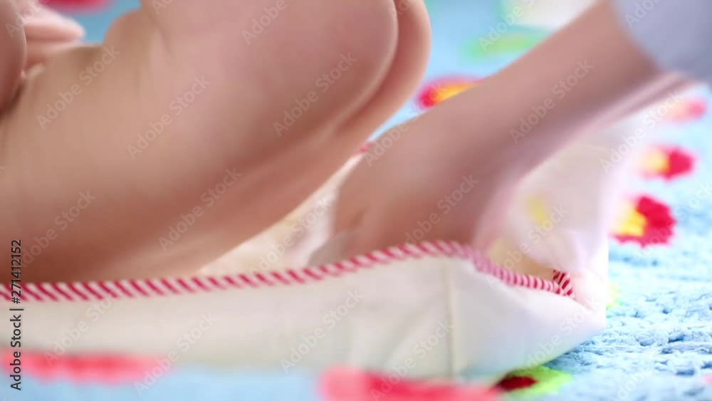 The mother changes the diaper for her newborn baby in the nursery. Newborn care, diaper change, healthy baby.