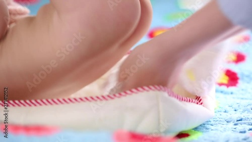 The mother changes the diaper for her newborn baby in the nursery. Newborn care, diaper change, healthy baby.