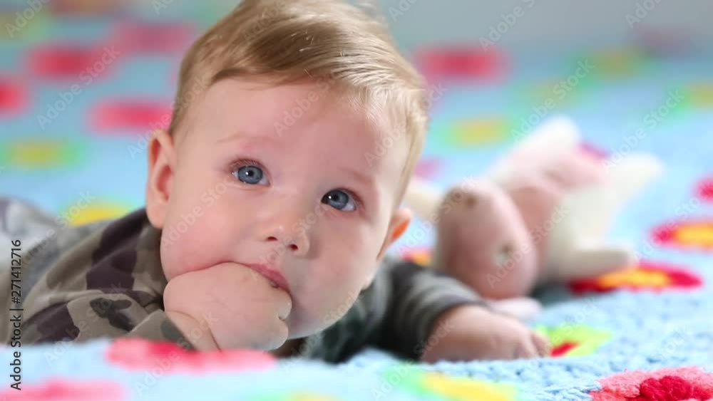 Beautiful Smiling Baby: A gorgeous little baby lies on the bed and smiles at the camera with a nice soft focus background Beautiful Smiling Baby: A gorgeous little baby lies on the bed and smiles at the camera with a nice soft focus background