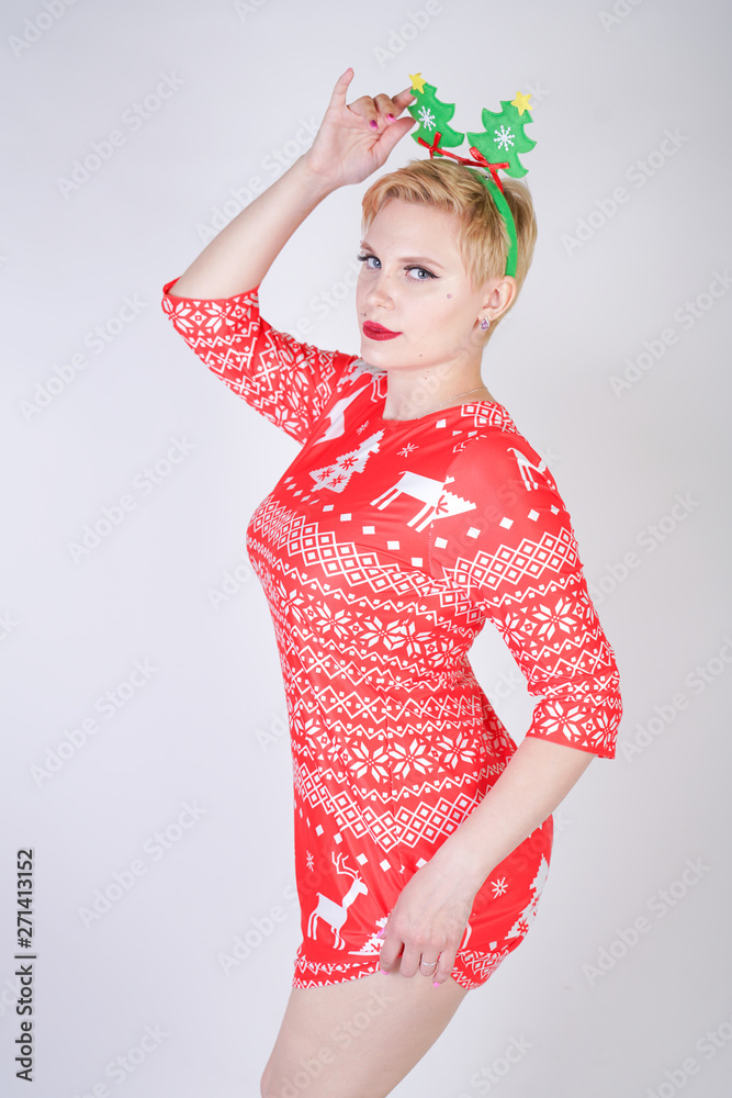 pretty blonde girl with short hair wearing christmas funny bright dress on white studio background alone pretty blonde girl with short hair wearing christmas funny bright dress on white studio background alone