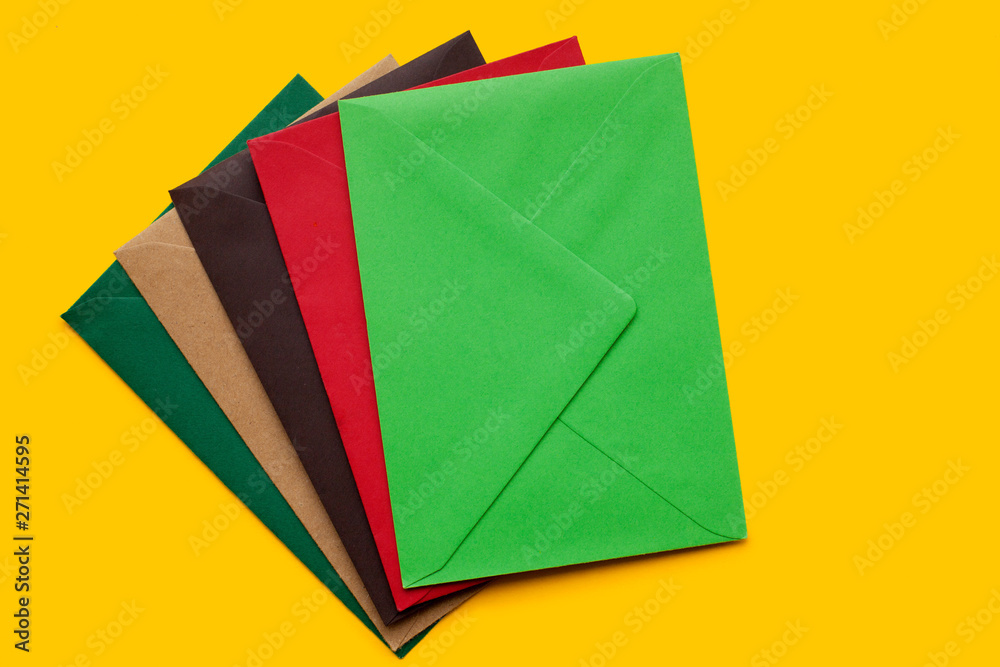Red, brown, green envelope on yellow background, top view Red, brown, green envelope on yellow background, top view