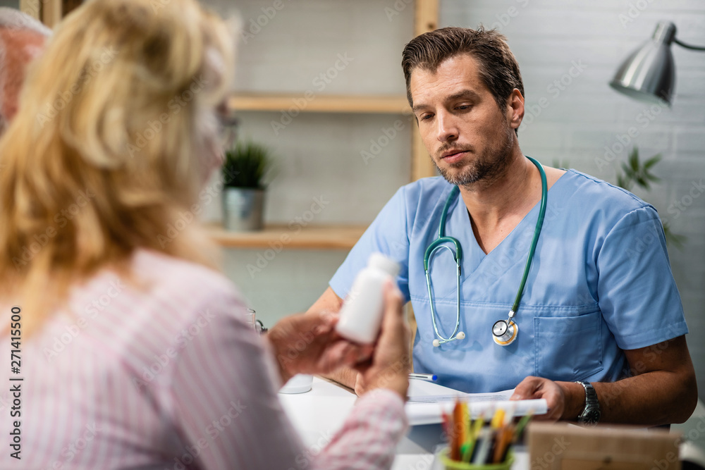 Obraz premium Male doctor having medical appointment with senior couple at his office.