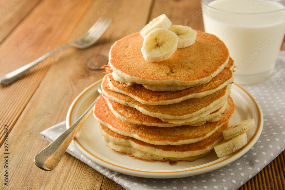 Stack of pancakes with banana slices and honey, on wooden background. Homemade american pancakes, isolated. Stack of pancakes with banana slices and honey, on wooden background. Homemade american pancakes, isolated.