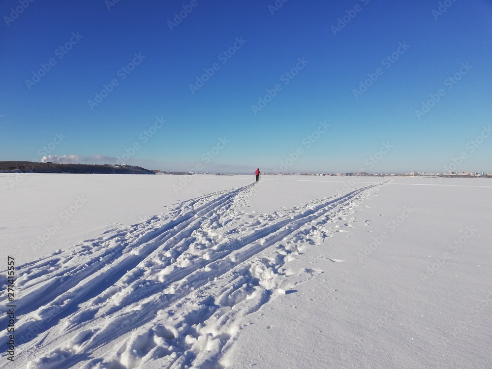 winter landscape with snow and blue sky and trails
