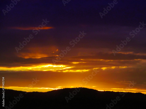 Landscape with sunset and silhouettes of trees. Beautiful view of bright colorful sky happened on evening decline in the summer evening.