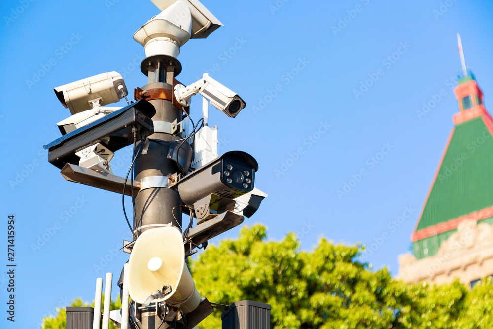 Various video surveillance security cameras. CCTV security cameras on the street pylon against blue summer sky Various video surveillance security cameras. CCTV security cameras on the street pylon against blue summer sky