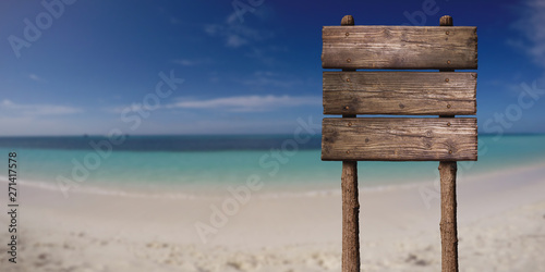 Wooden Board Sign at Sandy Beach at Tropical Island. Summer Vacation Concept