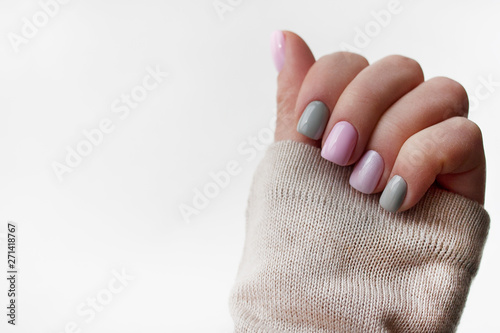 The pastel color manicure with the knitted sleeve of a brown sweater