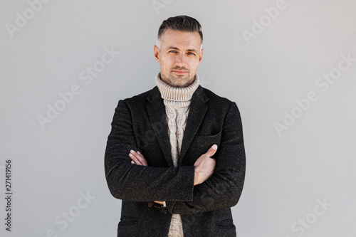 Attractive man wearing coat standing