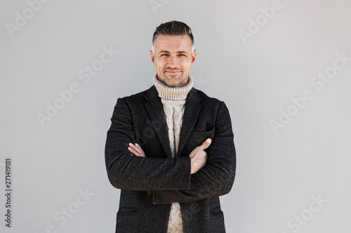 Attractive man wearing coat standing