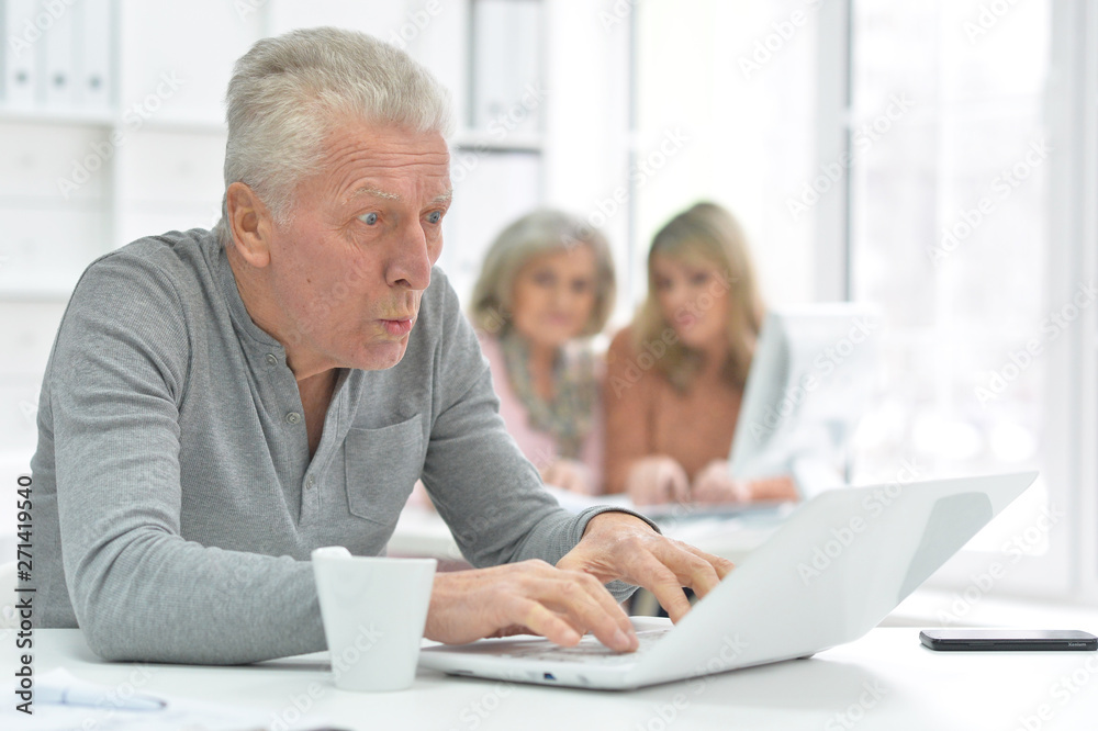 Portrait of senior man working with laptop at modern office Portrait of senior man working with laptop at modern office