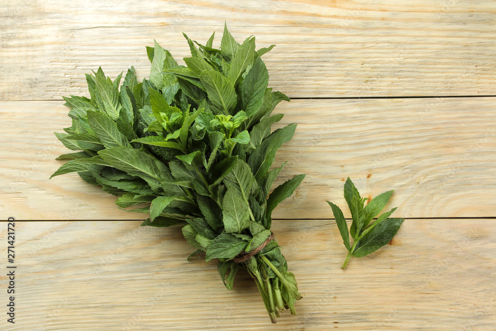 Mint. Leaves and branches of fresh green wild mint on a wooden natural table. top view Mint. Leaves and branches of fresh green wild mint on a wooden natural table. top view