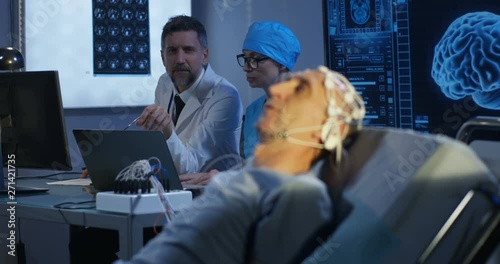 Patient lying in bed during EEG examination photo