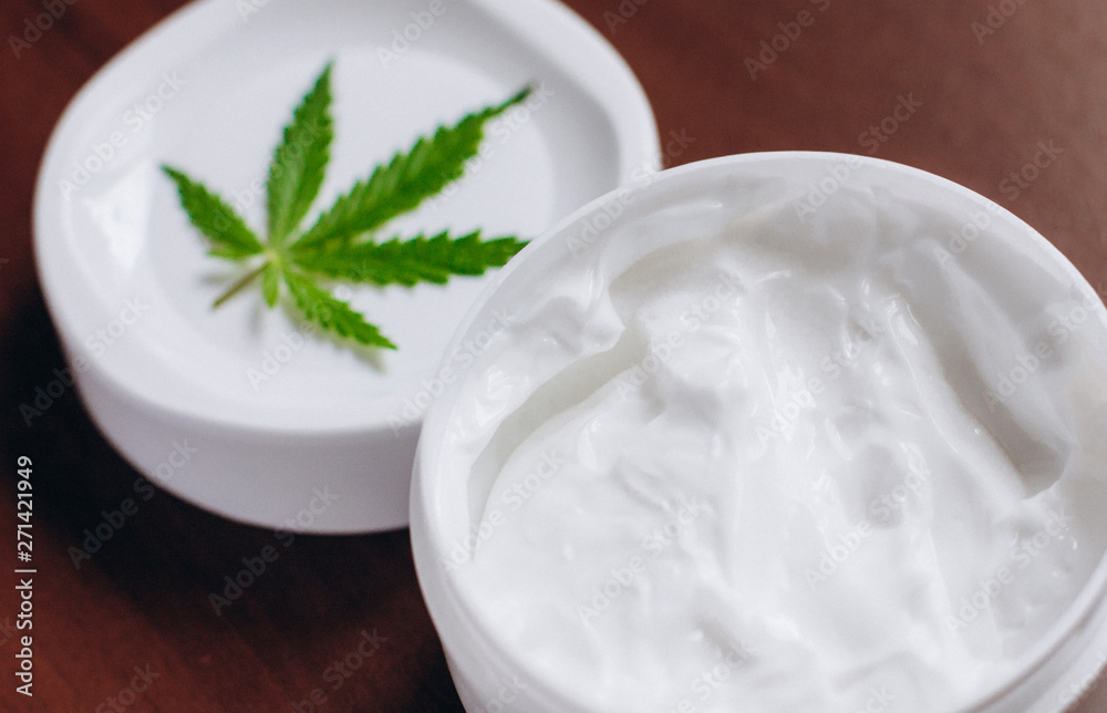 Detail of cannabis hemp cream with marijuana leaf - cannabis topicals concept. Cream from biological and ecological plants of hemp vegetable pharmaceutical oil CBD Detail of cannabis hemp cream with marijuana leaf - cannabis topicals concept. Cream from biological and ecological plants of hemp vegetable pharmaceutical oil CBD