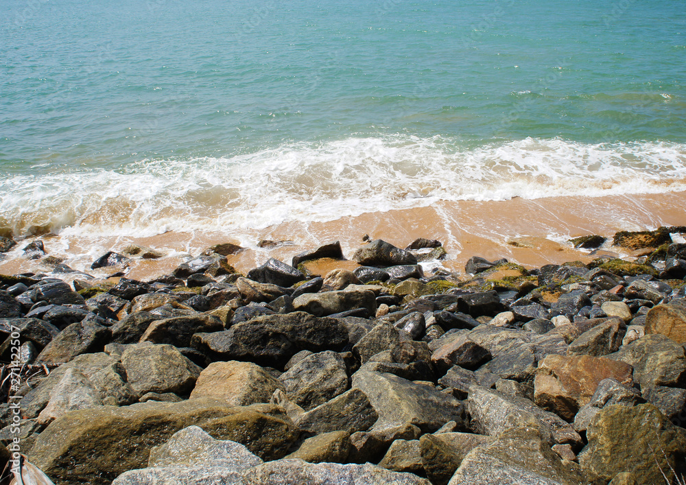 Southern tropical summer ocean coast with rocks and rocks. Lagoon with a yellow sandy beach and azure water. Southern tropical summer ocean coast with rocks and rocks. Lagoon with a yellow sandy beach and azure water.