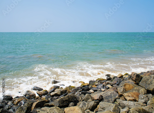 Southern tropical summer ocean coast with rocks and rocks. Lagoon with a yellow sandy beach and azure water. © Payllik