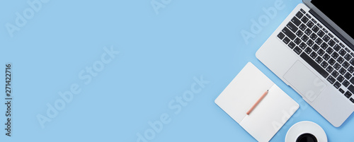 Girl write on open white book or accounting on a minimal clean light blue desk with laptop and accessories, copy space, flat lay, top view, mock up photo